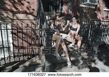 Woman looking at her friend flexing muscle and smiling View Large Photo Image Stock Photo - Woman looking at her friend flexing muscle and smiling. Fotosearch