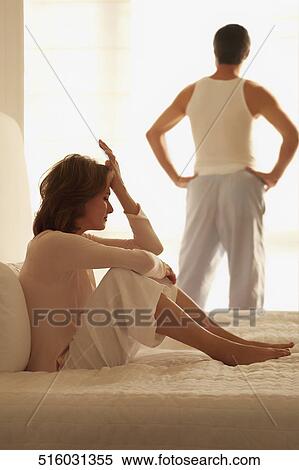 Woman looking sad with a man standing in the background View Large Photo Image Stock Photography - Woman looking sad with a man standing in the background. Fotosearch