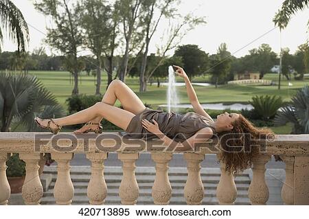 Stock Photography - Woman lying on the balustrade in a hotel, Biltmore Hotel, Coral Gables, Florida, USA. Fotosearch