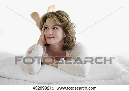Woman lying on the bed and day dreaming View Large Photo Image Stock Photography - Woman lying on the bed and day dreaming. Fotosearch