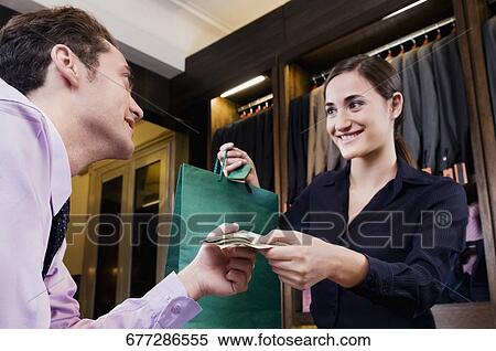 Woman paying in a clothing store View Large Photo Image Stock Photography - Woman paying in a clothing store. Fotosearch