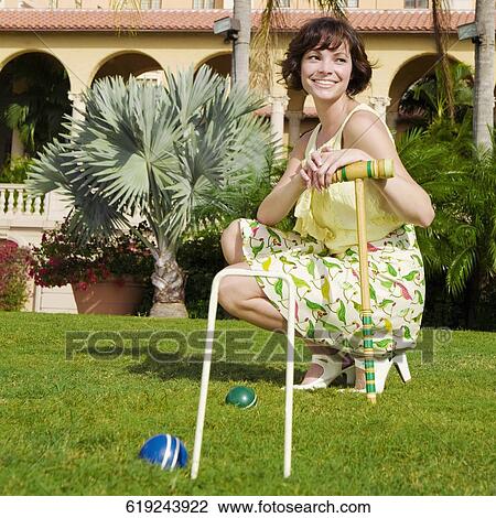 Stock Image - Woman playing croquet in a hotel lawn, Biltmore Hotel, Coral Gables, Florida, USA. Fotosearch
