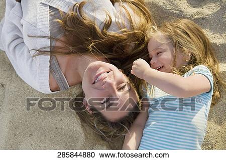 Stock Image - Woman playing with her daughter on the beach, Cabo San Lucas, Mexico. Fotosearch