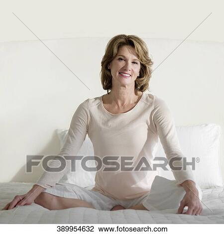 Woman practicing yoga on the bed View Large Photo Image Stock Image - Woman practicing yoga on the bed. Fotosearch
