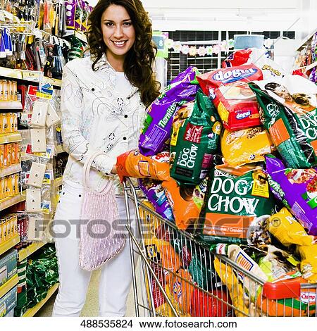 Woman pushing shopping cart loaded with dog foods View Large Photo Image Picture - Woman pushing shopping cart loaded with dog foods. Fotosearch