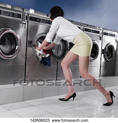 Woman putting clothes into a washing machine View Large Photo Image Stock Image - Woman putting clothes into a washing machine. Fotosearch