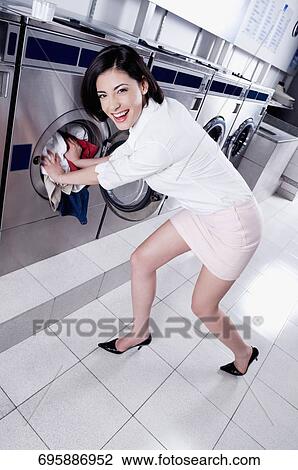 Woman putting clothes into a washing machine View Large Photo Image Stock Image - Woman putting clothes into a washing machine. Fotosearch