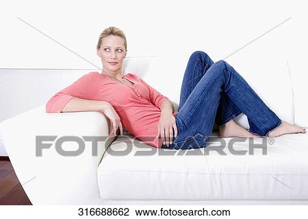 Woman reclining on a couch and day dreaming View Large Photo Image Stock Image - Woman reclining on a couch and day dreaming. Fotosearch
