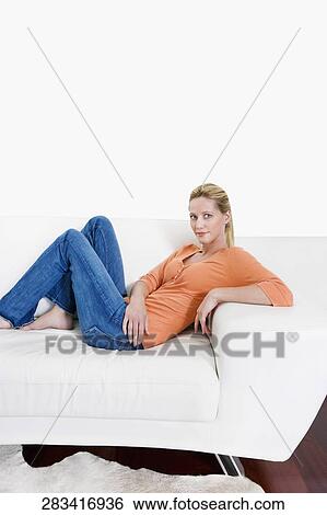 Stock Photograph - Woman reclining on a couch. Fotosearch