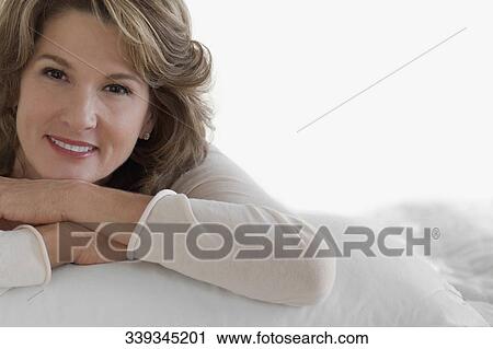 Stock Image - Woman relaxing on the bed. Fotosearch