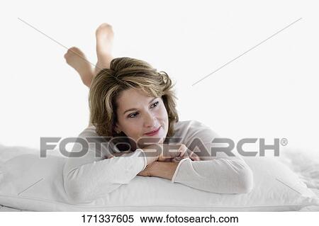 Woman relaxing on the bed View Large Photo Image Stock Photography - Woman relaxing on the bed. Fotosearch