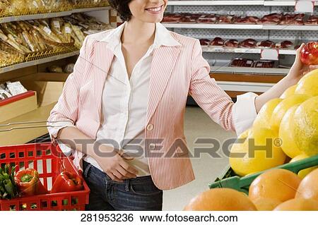 Stock Photograph - Woman shopping fruits in a supermarket. Fotosearch
