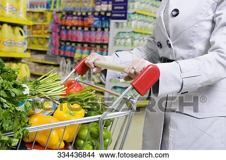 Woman shopping vegetables in a supermarket View Large Photo Image Picture - Woman shopping vegetables in a supermarket. Fotosearch