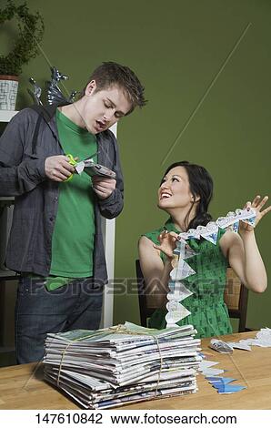 Stock Image - Woman showing a paper chain to a man. Fotosearch