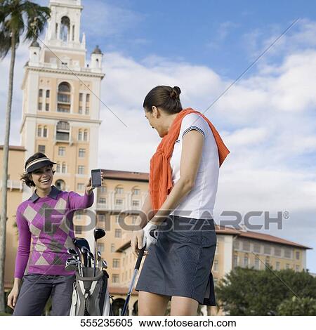 Stock Photography - Woman showing her mobile phone to a golfer, Biltmore Golf Course, Biltmore Hotel, Coral Gables, Florida, USA. Fotosearch