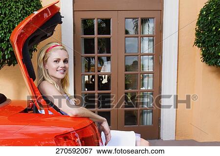 Woman sitting in a car trunk and smiling, Biltmore Hotel, Coral Gables, Florida, USA View Large Photo Image Stock Photo - Woman sitting in a car trunk and smiling, Biltmore Hotel, Coral Gables, Florida, USA. Fotosearch