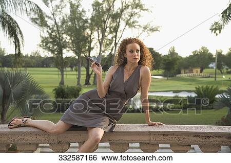 Woman sitting on balustrade and smoking a cigar, Biltmore Hotel, Coral Gables, Florida, USA View Large Photo Image Stock Photograph - Woman sitting on balustrade and smoking a cigar, Biltmore Hotel, Coral Gables, Florida, USA. Fotosearch