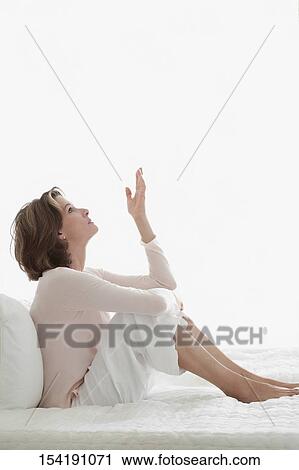 Woman sitting on the bed and thinking View Large Photo Image Stock Image - Woman sitting on the bed and thinking. Fotosearch