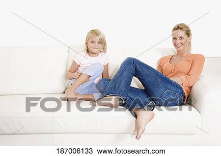 Woman sitting with her daughter on a couch View Large Photo Image Stock Image - Woman sitting with her daughter on a couch. Fotosearch