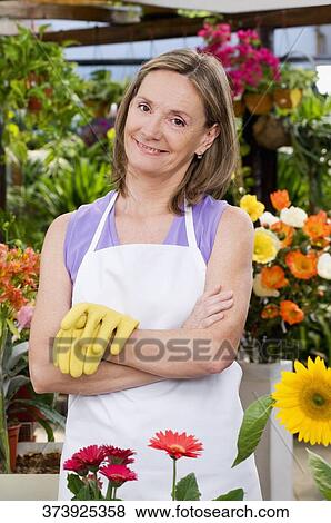 Woman standing in a greenhouse View Large Photo Image Stock Photo - Woman standing in a greenhouse. Fotosearch