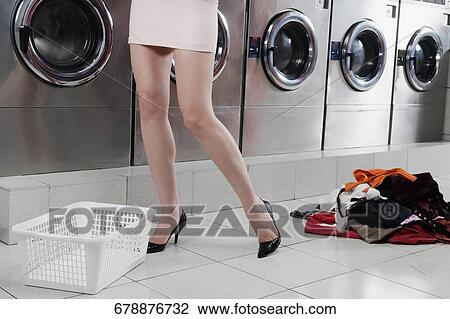 Woman standing in a laundromat View Large Photo Image Stock Image - Woman standing in a laundromat. Fotosearch