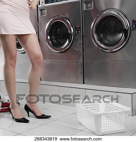Woman standing in a laundromat View Large Photo Image Stock Photo - Woman standing in a laundromat. Fotosearch