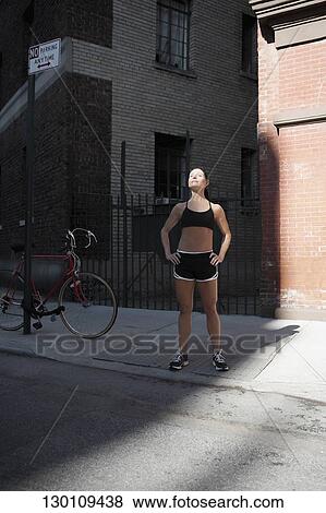 Stock Photo - Woman standing with arms akimbo. Fotosearch