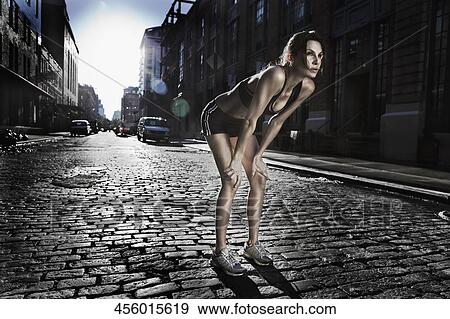 Woman standing with her hands on knees after exercise View Large Photo Image Stock Photo - Woman standing with her hands on knees after exercise. Fotosearch
