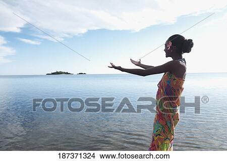 Woman stretching her arms towards the sea View Large Photo Image Picture - Woman stretching her arms towards the sea. Fotosearch