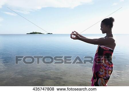 Woman stretching her arms towards the sea View Large Photo Image Stock Photo - Woman stretching her arms towards the sea. Fotosearch
