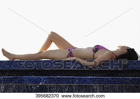 Woman sunbathing at the poolside View Large Photo Image Stock Image - Woman sunbathing at the poolside. Fotosearch
