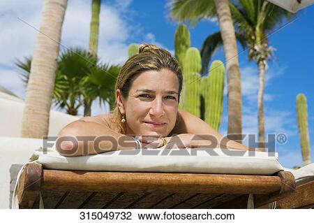 Stock Image - Woman sunbathing on the beach, Cabo San Lucas, Mexico. Fotosearch