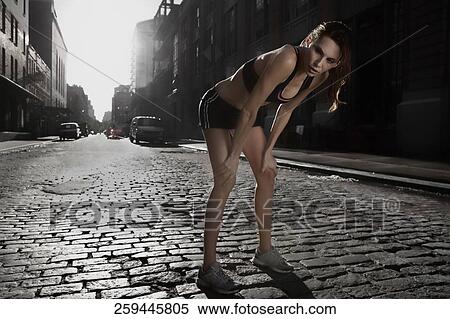 Stock Photography - Woman taking a break during exercise. Fotosearch