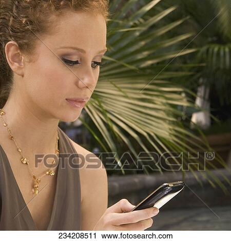 Woman text messaging on a mobile phone, Biltmore Hotel, Coral Gables, Florida, USA View Large Photo Image Stock Image - Woman text messaging on a mobile phone, Biltmore Hotel, Coral Gables, Florida, USA. Fotosearch