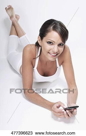 Stock Image - Woman text messaging on a mobile phone. Fotosearch