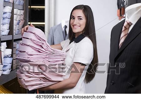 Woman working in a clothing store View Large Photo Image Picture - Woman working in a clothing store. Fotosearch