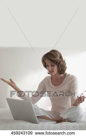 Stock Photo - Woman working on a laptop and looking upset. Fotosearch