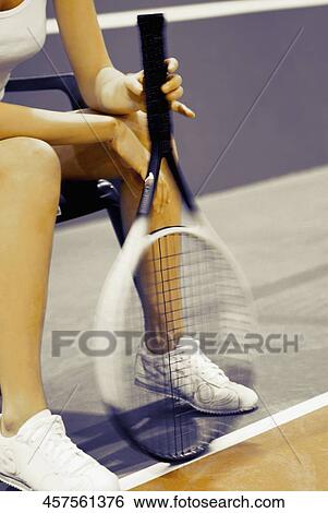 Woman's hand holding a tennis racket and sitting on a chair View Large Photo Image Stock Photograph - Woman's hand holding a tennis racket and sitting on a chair. Fotosearch