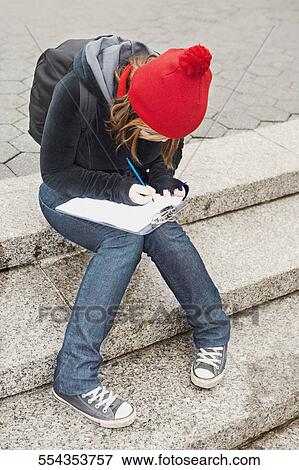 Young woman writing on a clipboard View Large Photo Image Stock Photo - Young woman writing on a clipboard. Fotosearch
