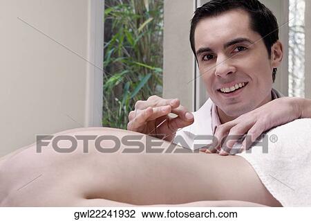 Acupuncturist applying needles on a person's back View Large Photo Image Stock Image - Acupuncturist applying needles on a person's back. Fotosearch