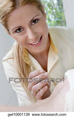Stock Photo - Acupuncturist applying needles on a person's back. Fotosearch