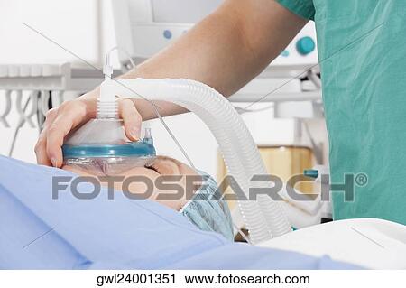 Anesthetist using an oxygen mask on a patient in a hospital View Large Photo Image Stock Image - Anesthetist using an oxygen mask on a patient in a hospital. Fotosearch