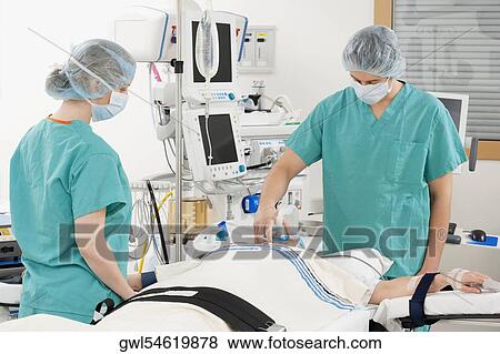 Anesthetist using an oxygen mask on a patient in a hospital View Large Photo Image Stock Photo - Anesthetist using an oxygen mask on a patient in a hospital. Fotosearch