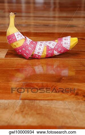 Banana wrapped in a tape measure View Large Photo Image Picture - Banana wrapped in a tape measure. Fotosearch