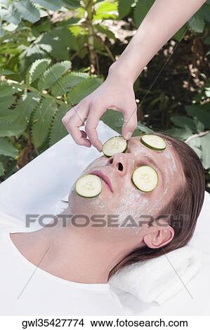 Beautician putting cucumber slices on a man's face View Large Photo Image Picture - Beautician putting cucumber slices on a man's face. Fotosearch