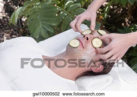 Beautician putting cucumber slices on a man's face View Large Photo Image Stock Image - Beautician putting cucumber slices on a man's face. Fotosearch