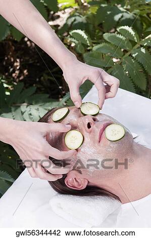 Beautician putting cucumber slices on a man's face View Large Photo Image Stock Image - Beautician putting cucumber slices on a man's face. Fotosearch