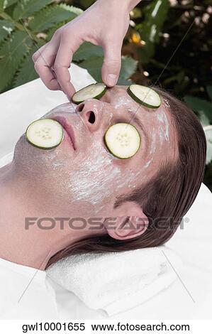 Beautician putting cucumber slices on a man's face View Large Photo Image Stock Photography - Beautician putting cucumber slices on a man's face. Fotosearch
