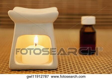 Stock Photo - Bottle of aromatherapy oil and a burner. Fotosearch