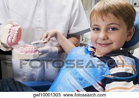 Boy learning how to brush teeth with the help of dentures in a dentist's office View Large Photo Image Stock Image - Boy learning how to brush teeth with the help of dentures in a dentist's office. Fotosearch